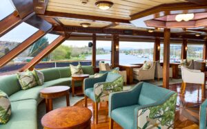 Lord of the Glens lounge area with bar, chairs, couch, tables and large picture windows throughout.