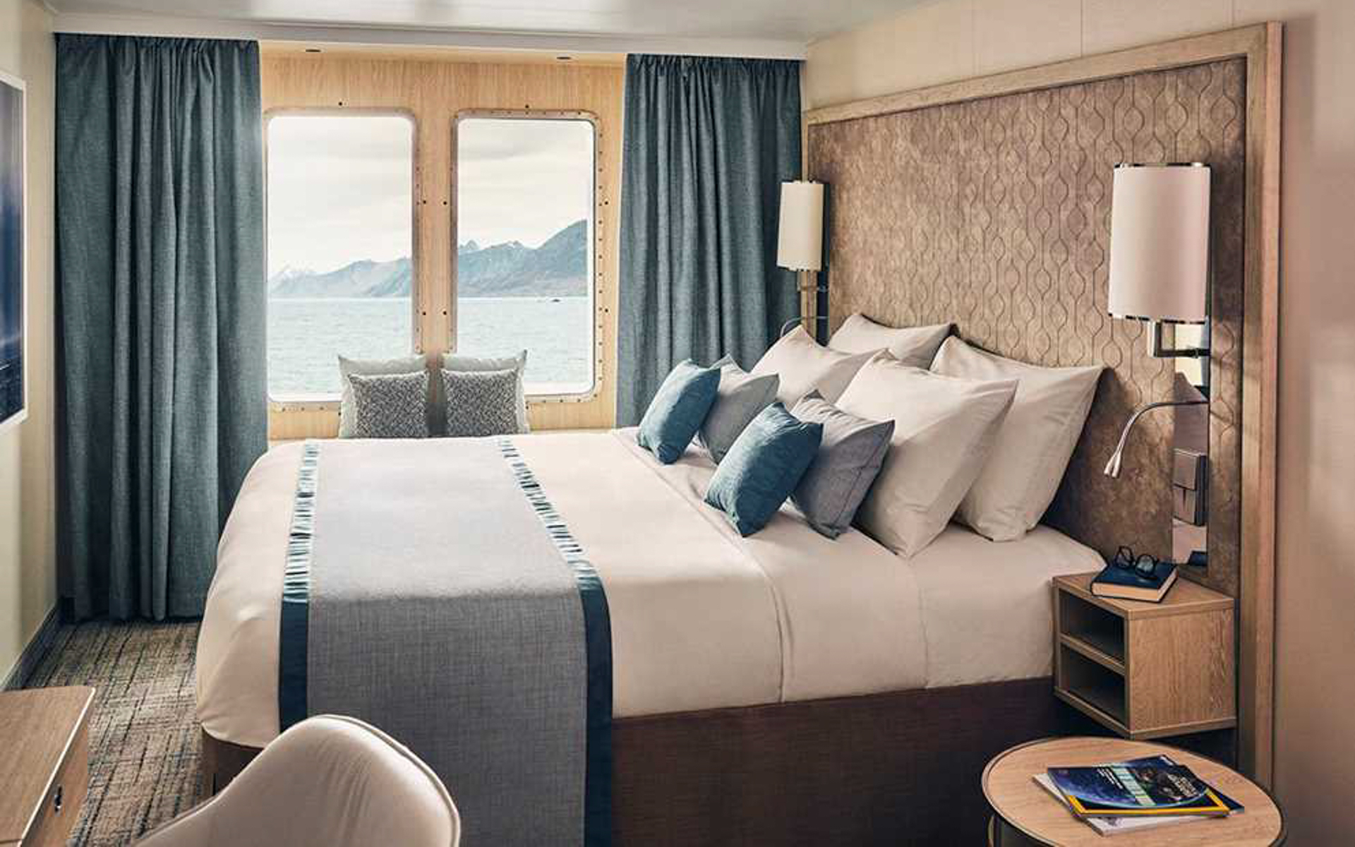 Window Suite with a large comfortable bed, two large windows aboard National Geographic Resolution polar expedition ship.