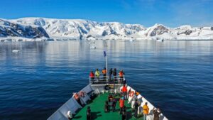 Ushuaia bow with passengers viewing a white mountain range in Alaska.