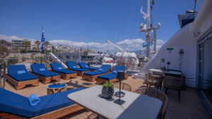 Outdoor sundeck on small cruise ship with blue lounge chairs and blue towels rolled up