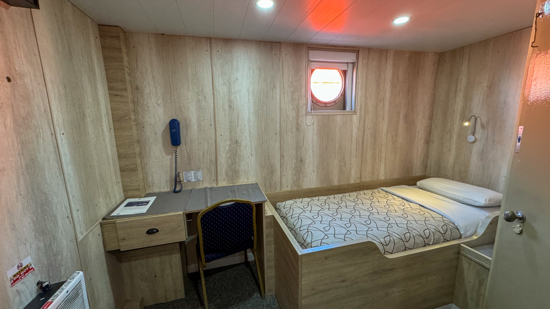 Ushuaia by Antarpply Expeditions to Antarctica featuring a Premier Single cabin with bed, desk, porthole and ample space