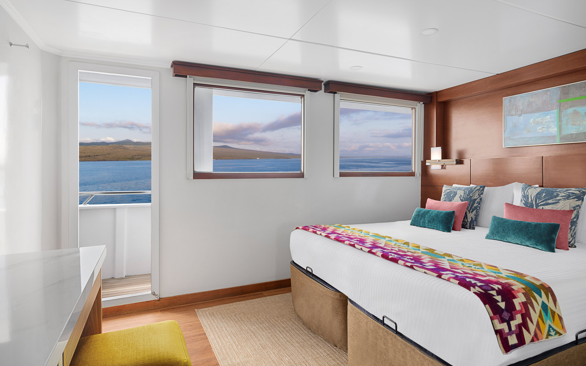 Category 4 Cabin aboard National Geographic Delfina with two windows, door to outside wrap around deck, one bed with photo above