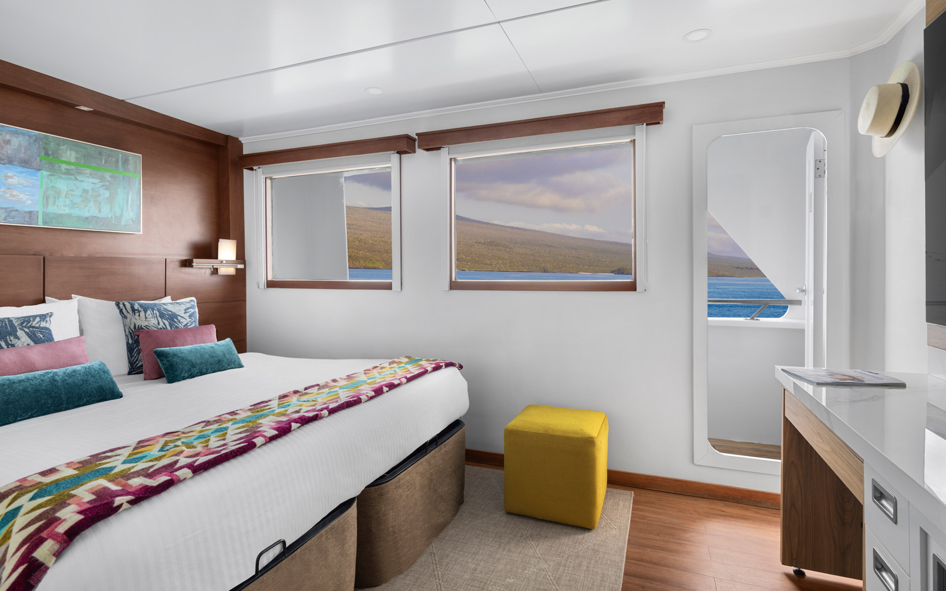 Category 5 Cabin aboard National Geographic Delfina with two windows, door to outside wrap around deck, one bed with photo above