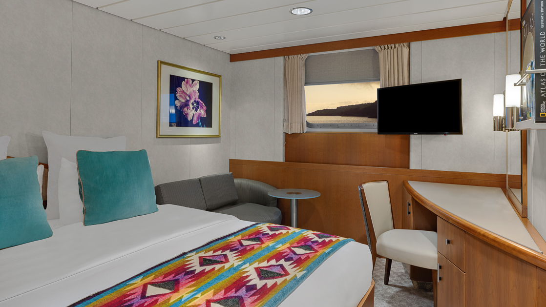Room about national geographic ship with double bed and small corner desk