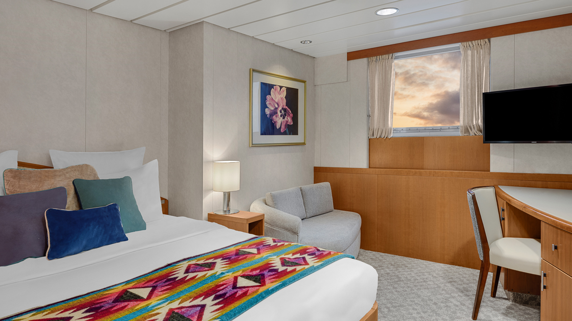 Room about national geographic ship with double bed and small corner desk