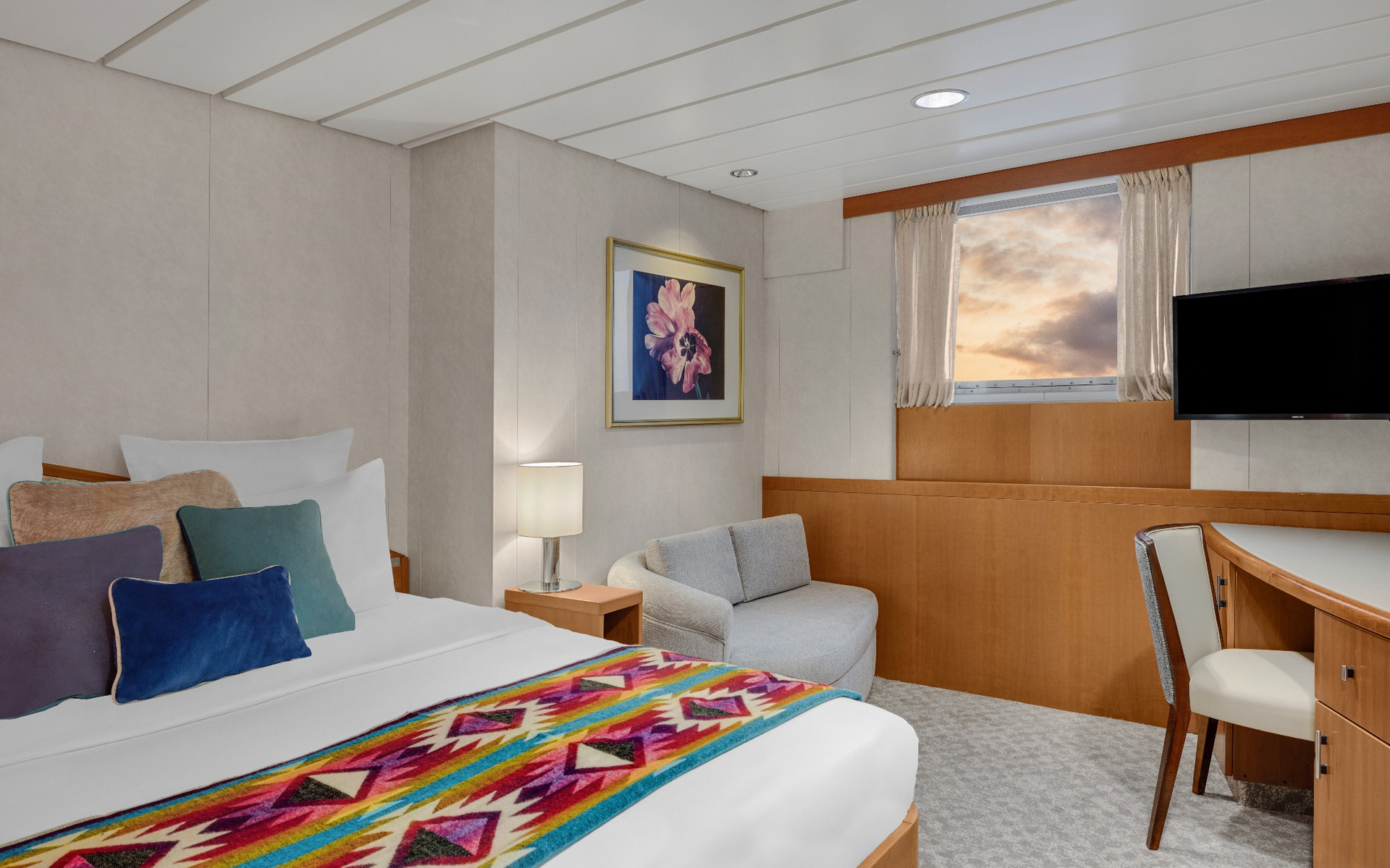 Category 2 & 2S cabin bed and sitting area aboard a Galapagos luxury yacht.