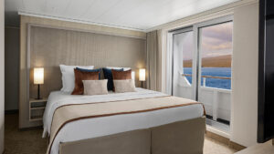 Category 7 Cabin aboard National Geographic Gemini. White bedding, glass door to balcon