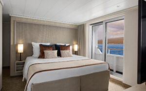 Category 7 cabin bedroom with ocean views aboard a Galapagos luxury yacht.