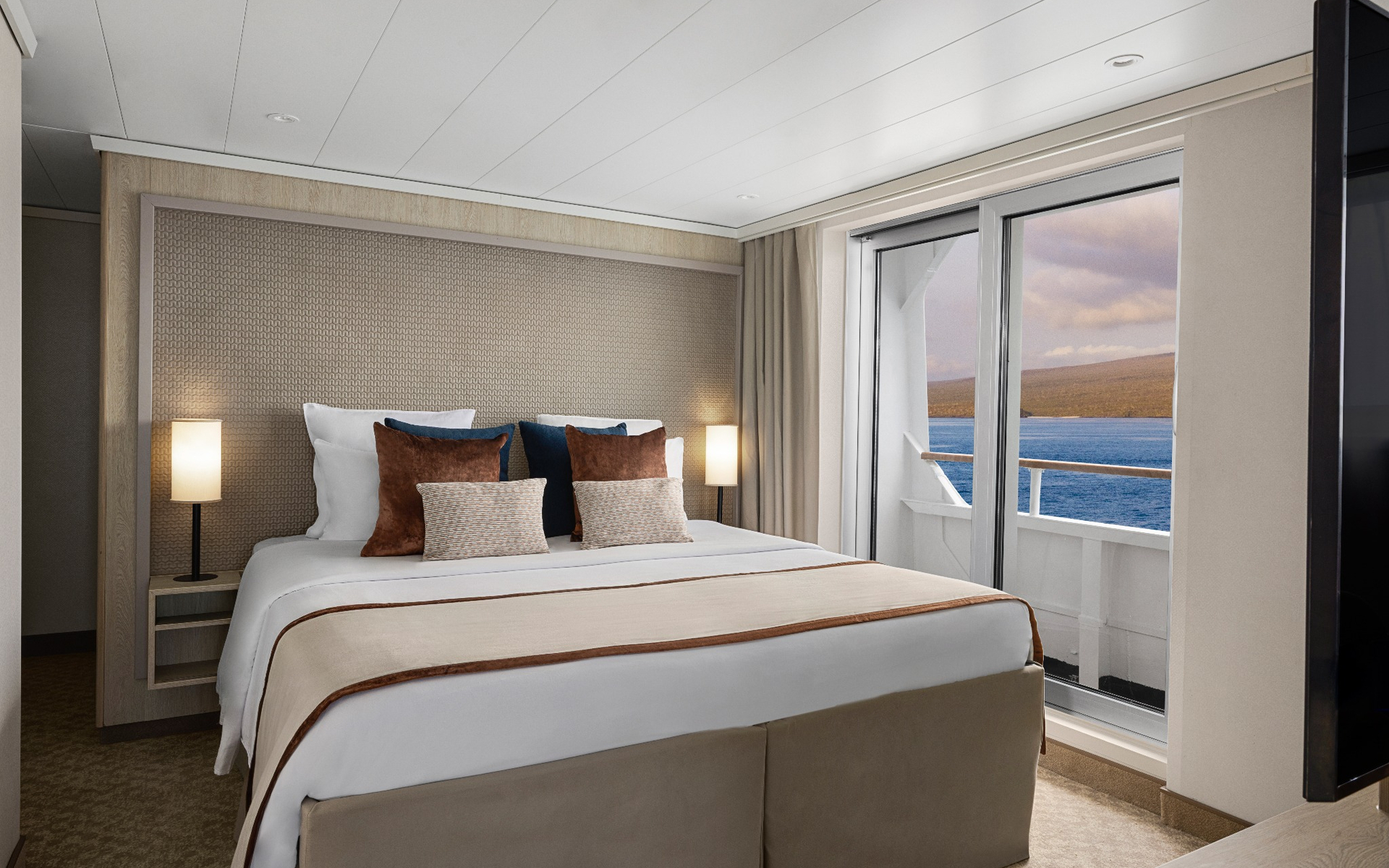 Category 7 cabin bedroom with ocean views aboard a Galapagos luxury yacht.
