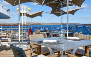 Outdoor dining tables overlooking the Galapagos from a luxury yacht.