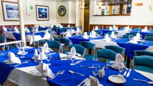 Ushuaia dining room with blue tableclothes and table set with wine glasses and plates.