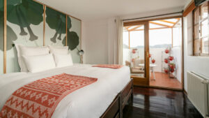 Double bed with white sheets modern design and a lovely patio for guests to enjoy.