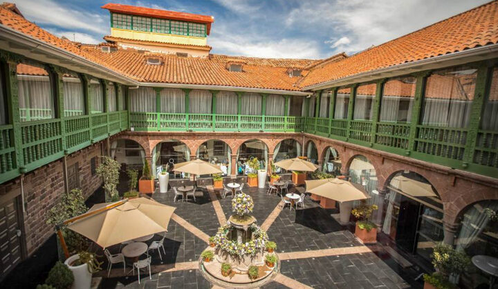 Exterior of Aranwa Cusco Boutique with green and red terracotta roofs ariel view of hotel on a sunny day