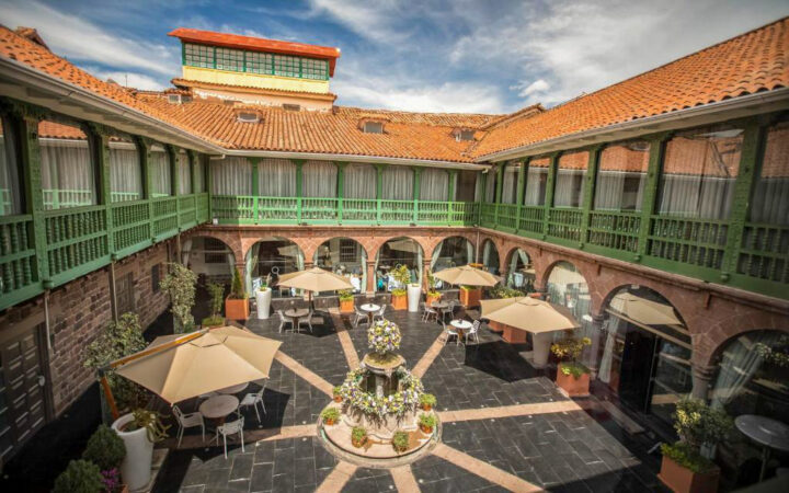 Exterior of Aranwa Cusco Boutique with green and red terracotta roofs ariel view of hotel on a sunny day