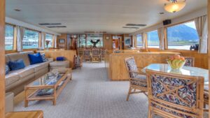 Large tan leather couch and coffee table across from another table in the lounge aboard Golden Eagle.