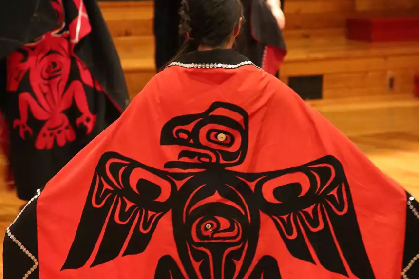 striking dance robe of all red with black eagle character worn by young female dancer. 