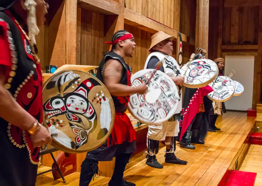 In Alaska, men give performance of traditional Inuit drum-songs, wearing mainly black and red and white celebratory clothes. 