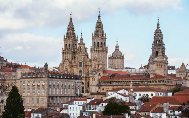 beautiful historic buildings towering over the city with red roofs on a cloudy day in Spain
