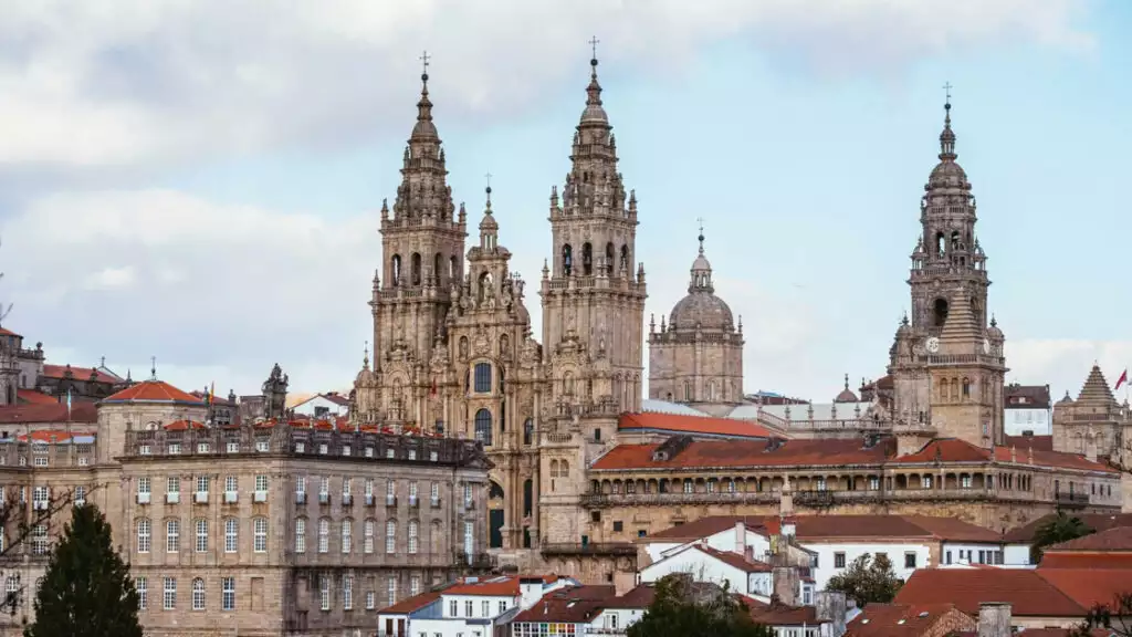 beautiful historic buildings towering over the city with red roofs on a cloudy day in Spain