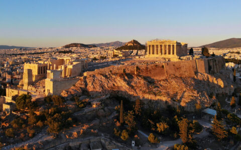 Aerial view of the Parthenon in Athens, a mountain-top ancient city of stone, at dusk in Greece.