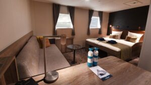 Plancius Antarctica small ship cabin with a large bed in front of two windows