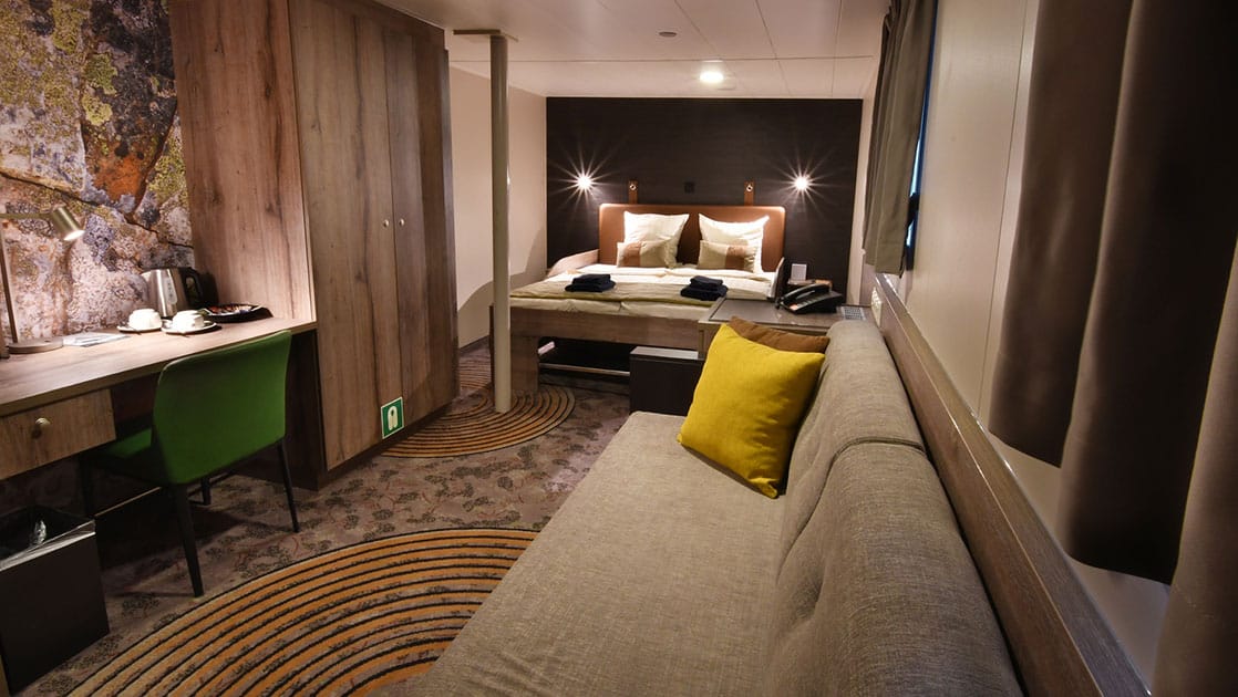 Plancius Antarctica small ship cabin with a large bed in front of a window