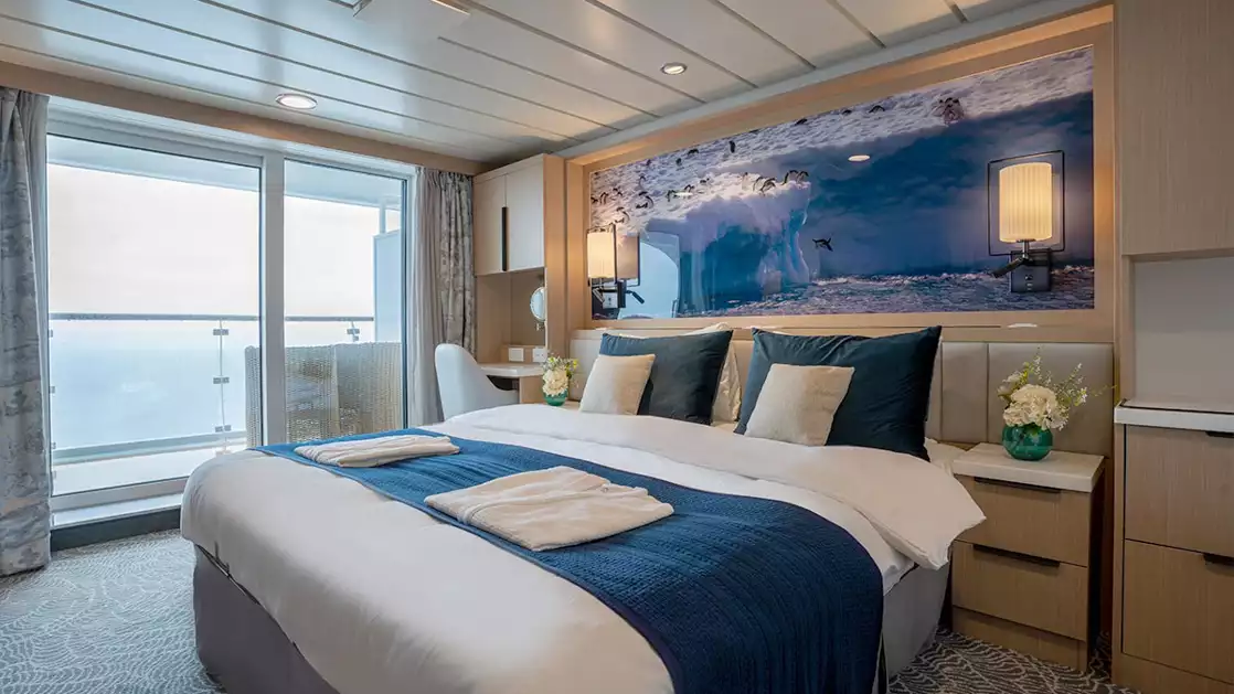double bed aboard small ship cruise in antarctica with blue and white tones and floor to celling windows