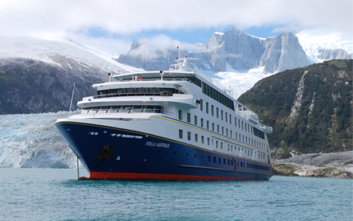 The Stella Australis in Chilean Patagonia seen here near a glacier releasing ice into the see with the dramatic Patagonian mountains