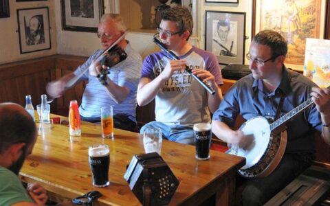 4 men play traditional Irish music in a pub during the Classic Ireland River Cruise.