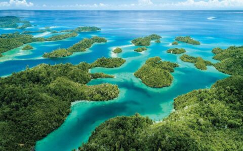 looking down the many of islands of indonesia with turquoise and aqua colored ocean in between