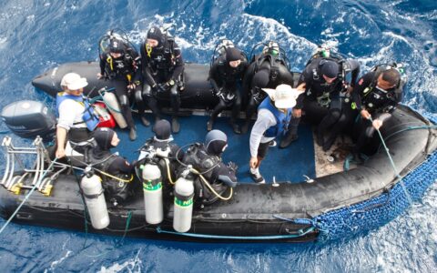 Aerial view down to panga boat loaded with ready divers on a windy day during the Galapagos Sky liveaboard dive cruises.