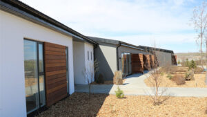 Exterior of northeast Iceland's Hotel 1001 Nott, with stone gardens, private guestroom patios, wood & white walls.