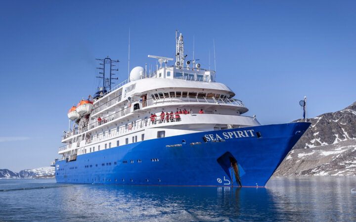 Exterior starboard side & bow of Sea Spirit polar expedition ship with blue hull & white upper decks.