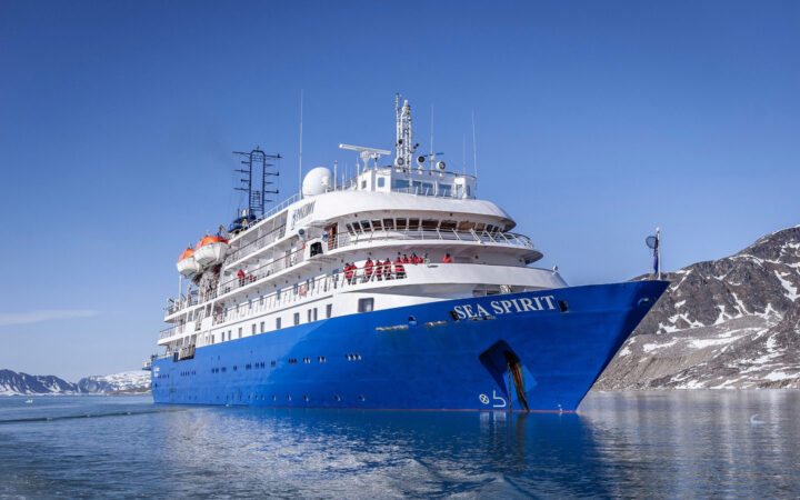 Exterior starboard side & bow of Sea Spirit polar expedition ship with blue hull & white upper decks.