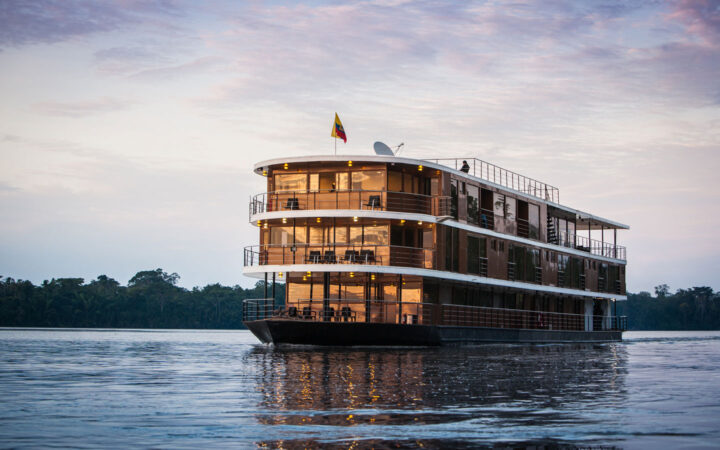 Anakonda small ship with 4 guest decks including open-air trop deck, in copper color, cruising the River.