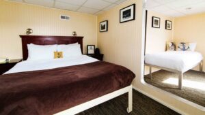 Deluxe Suite aboard Baranof Dream with large bed and mirror.