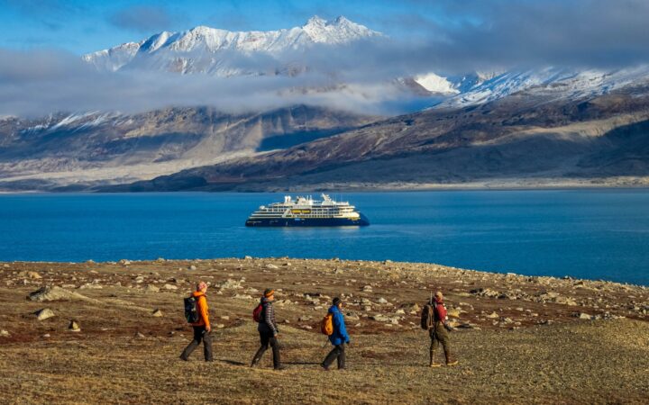 Beautiful mountains with ship in the background with a group of travelers West Coast Iceland and the East Coast of Greenland.