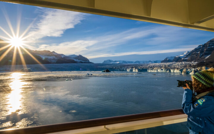 A guest takes photographs at Sunrise from the ship National Geographic Endurance, Northeast Greenland National Park, Greenland