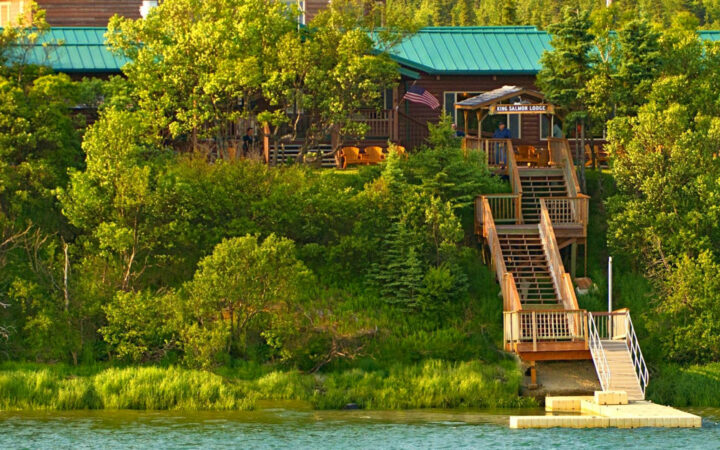 King Salmon Lodge located in Alaska nested into the woods with stairs leading down to a dock with waterfront access.