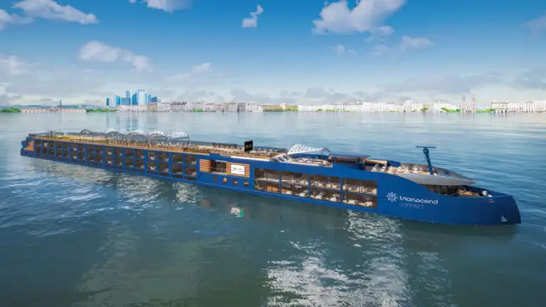 Modern blue riverboat National Geographic Connect with open-air teak top deck sits in calm sea on a sunny day in Europe.