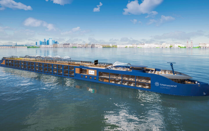 Modern blue riverboat National Geographic Connect with open-air teak top deck sits in calm sea on a sunny day in Europe.