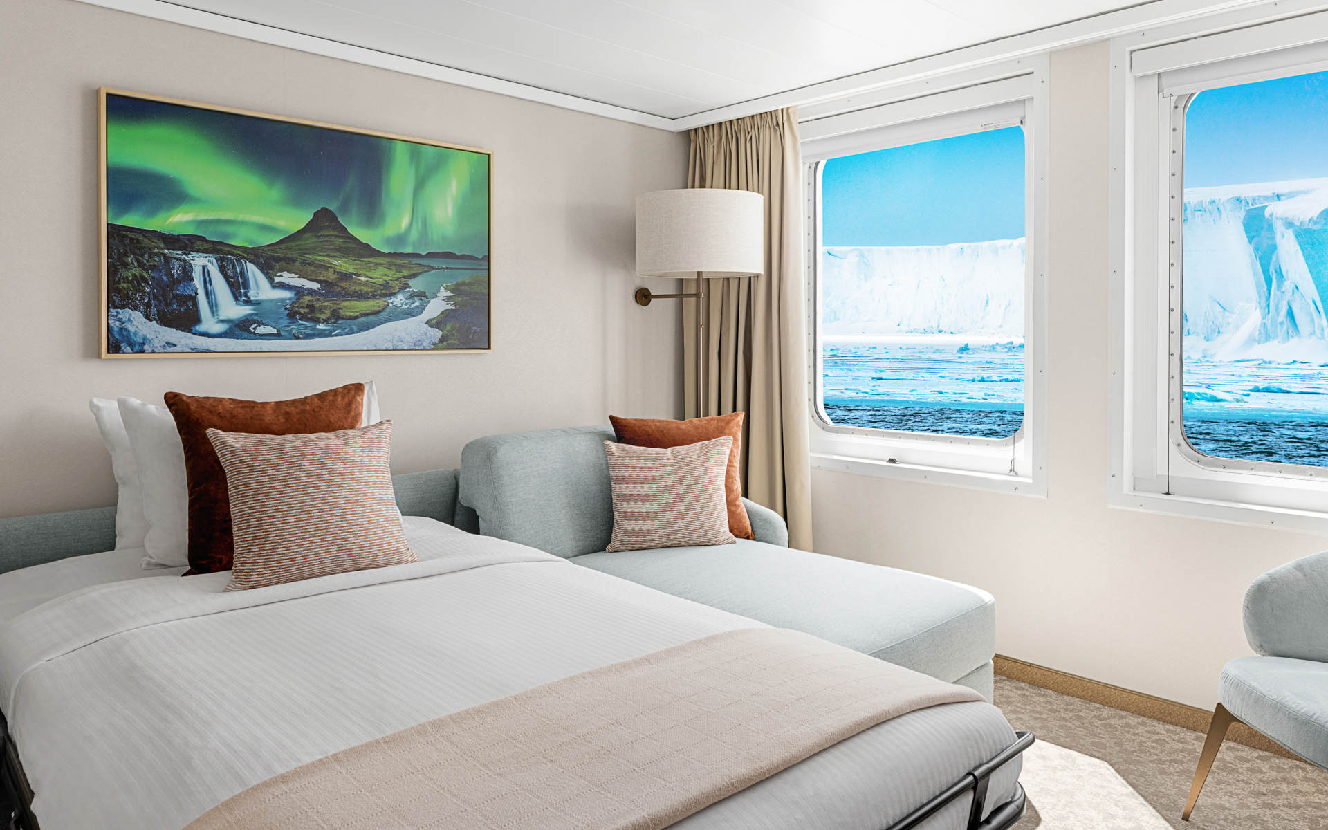 Rendering of Category 6 Suite on Nat Geo Explorer ship with double bed, chaise lounge chair, light colors & window onto ice & snow.