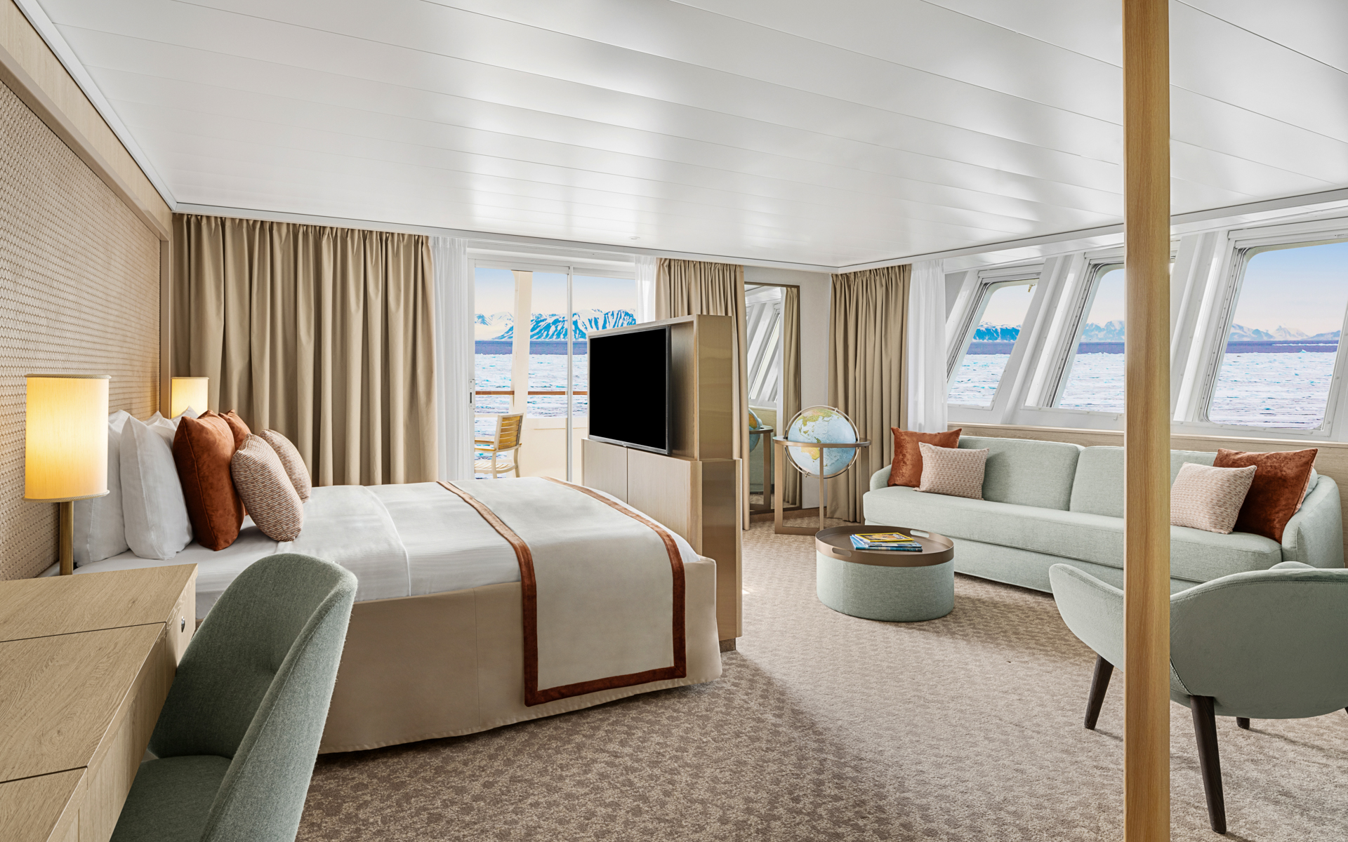 A large room with a sliding glass door and a bank of windows looking out on the Antarctic aboard the National Geographic Explorer