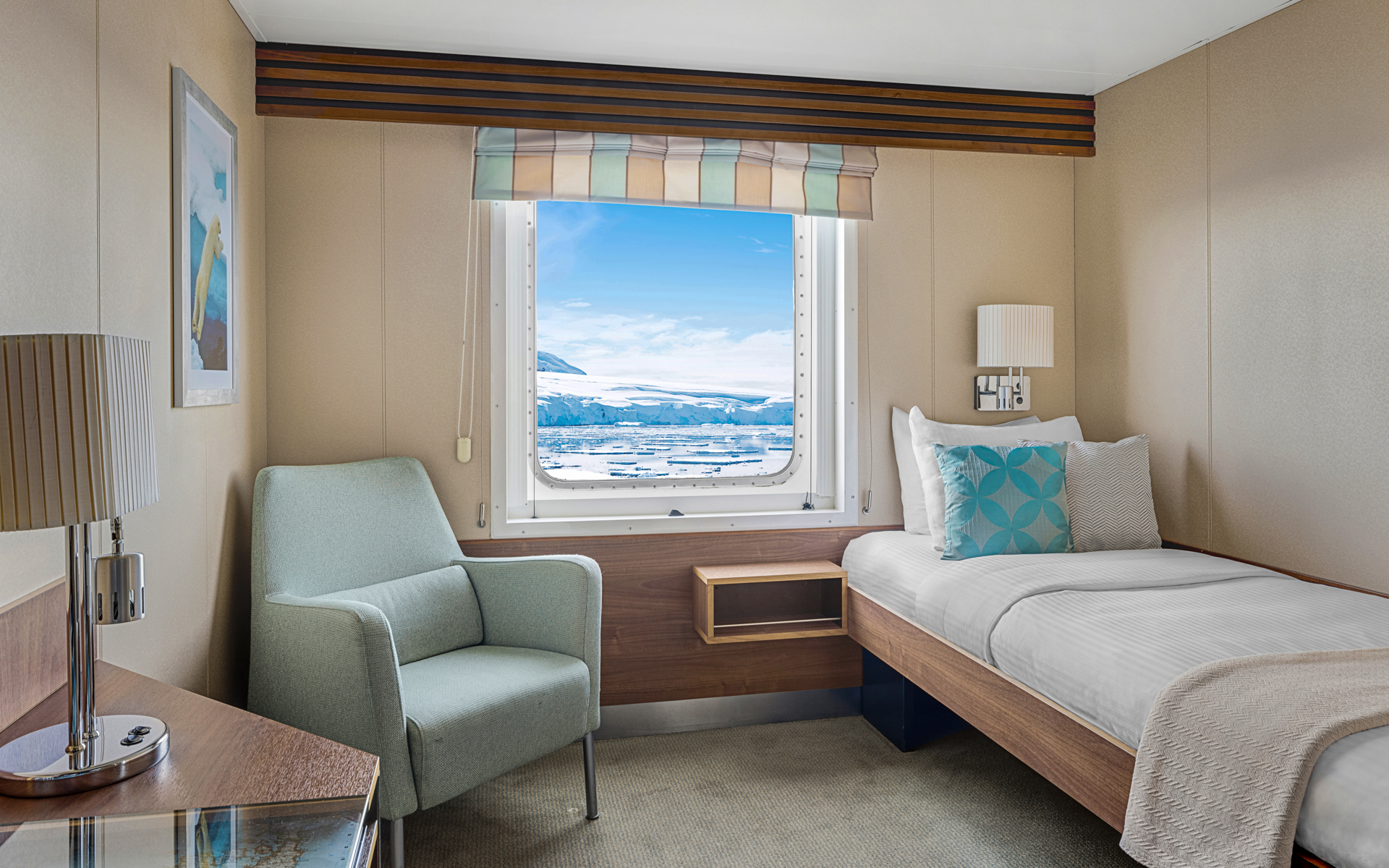 Category B Solo cabin with bed, nightstand, desk, chair and large window aboard National Geographic Explorer polar expedition ship