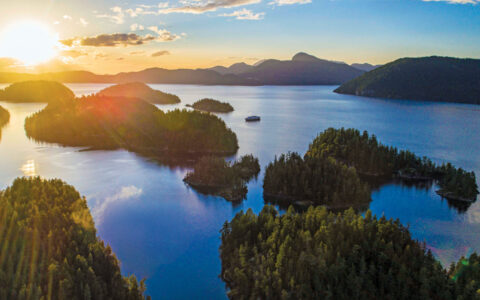 Aerial view of gumdrop green islands at sunset, seen on the Remarkable Journey to Alaska, British Columbia & Haida Gwaii cruise.