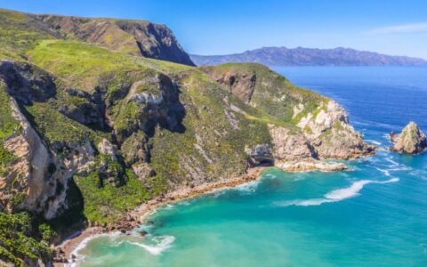 aerial of secluded bay with turquoise water and large cliffs in channel islands