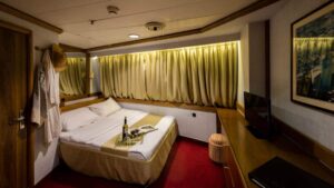 panorama luxury yacht cabin with a double bed and curtains over the large window