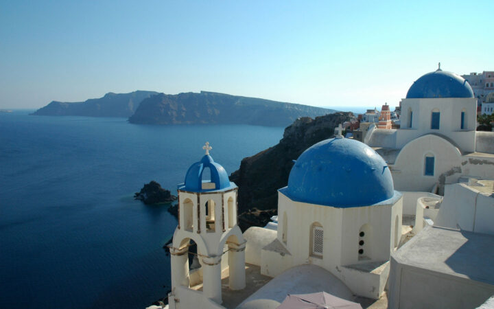 white buildings with blue domed roofs along the classical greece cruise in the mediterranean