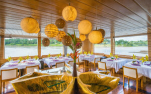 Dining room of the Delfin II amazon small river boar, outfitted with luxurious chairs and tables sourced from the region.