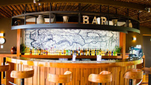 Stools surround a well-lit and well-stocked semicircle bar aboard Delfin III riverboat on Amazon River cruise